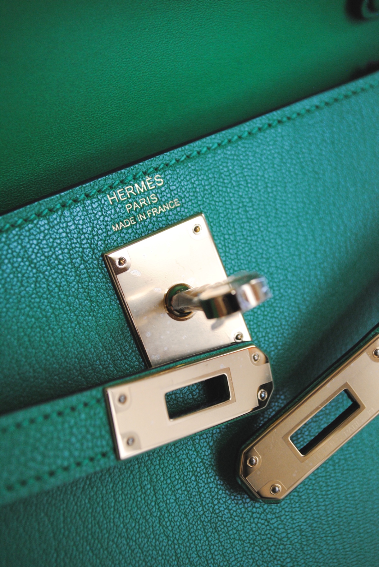 Palladium turn-lock hardware on emerald chevre leather